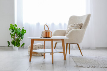 Interior of light living room with armchair and coffee table