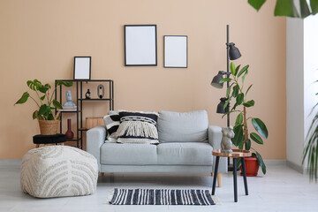 Interior of living room with sofa, coffee table, pouf and shelving unit