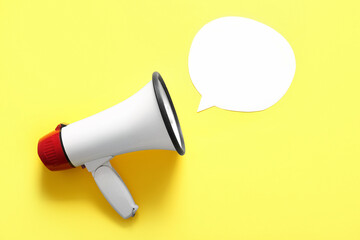 Megaphone with blank speech bubble on yellow background. Gossip concept