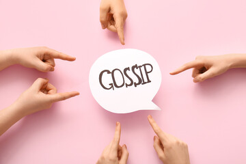 Women pointing at speech bubble with word GOSSIP on pink background