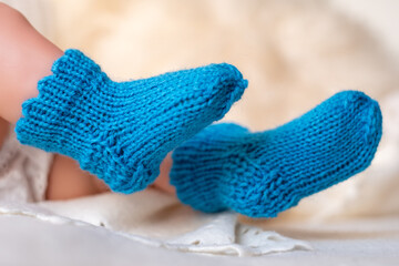 Soft handmade blue baby booties on a cozy white blanket, showcasing intricate knitting detail, perfect for newborns or infants