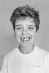 Black and white portret of a boy missing his teeth 
