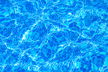 Background texture surface of blue swimming pool of water with refractive sun