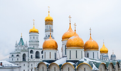 The majestic golden domes of the Kremlin church towers stand out against a cloudy winter sky, showcasing Russia's rich architectural heritage in Moscow. Golden domes of Russian architecture.