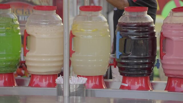 This video shows a colorful and delicious row of agua frescas beverage dispensers. 