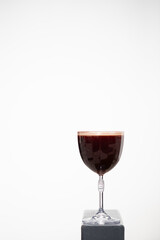 Elegant dark beverage served in crystal glass against a minimalist backdrop showcasing its rich color and texture