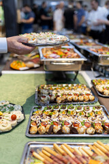 A banquet spread featuring an array of appetizers and delicacies at a vibrant event during the evening