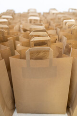 Numerous brown paper bags arranged neatly for a community event on a bright day at a local venue