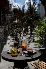 Enjoying refreshing drinks and pastries on a sunny afternoon at an outdoor café in the city