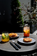 Enjoying a leisurely brunch with drinks and pastries on a sunlit patio in a vibrant urban setting
