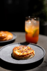 Deliciously grilled pastry with a refreshing drink on a sunny table outdoors in a vibrant cafe setting