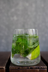 Refreshing mojito cocktail with mint and lime served in a clear glass on a wooden surface