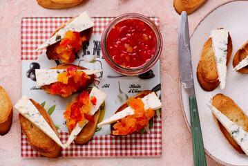Crostini with Sweet Pepper Jam and Blue Cheese on the cutting board. selective focus