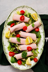 Snack rolls of ham with avocado and cream cheese for a breakfast