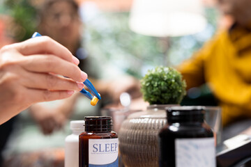 Social caregiver separating the medicaments and supplements pills, preparing daily doses for both senior people at home. Putting the capsules in two different bottles, healthcare medicine. Close up.
