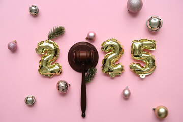 Figure 2025 with judge's gavel and Christmas balls on pink background