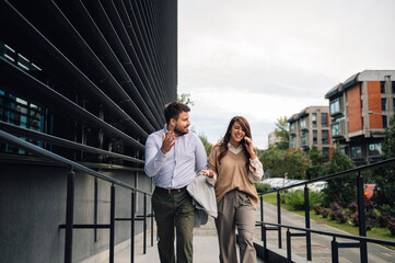 Business people leaving office building talking on phone