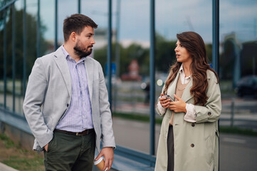 Business people having conversation walking outside modern office building