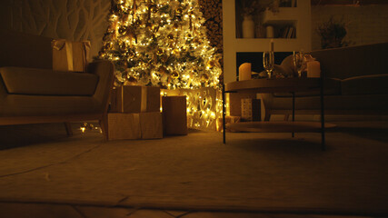 Warm and inviting living room is glowing with christmas lights, with presents piled beneath the tree and a table set for a festive celebration
