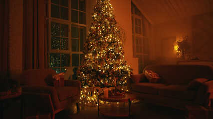Decorated christmas tree is standing between two armchairs, illuminating a cozy living room with warm lights at night