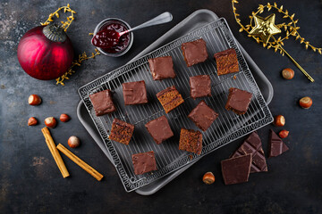 Homemade Fudgy brownies domino cake pastry cubes with marmalade and dark chocolate topping glaze served as top view on a cooling rack