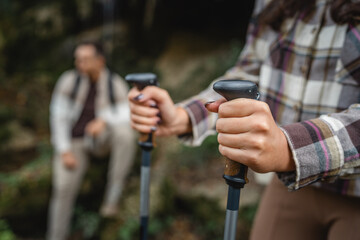 close up of unknown adult woman hold hiking sticks, trekking poles