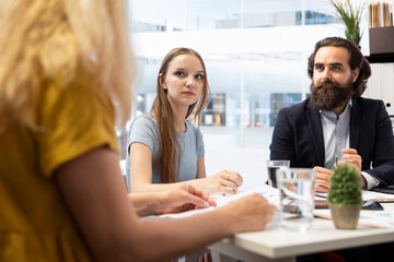 Financial advisors meeting with clients to counsel them on their finances and give them personalized financial plan. Agent guiding family in making profitable and secure decisions