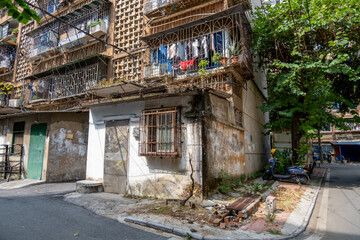 A weathered, dilapidated residential apartment building in a low-income neighborhood in China shows...