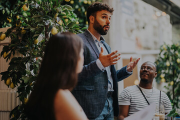 A diverse group of business professionals discussing ideas and strategies in a contemporary coffee...