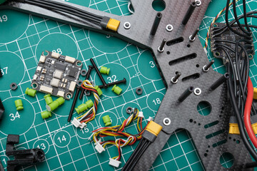 stack of disassembled sport FPV drone bodies lies on a work table, alongside DIY electronic speed controllers, ready for servicing and flight assembly.