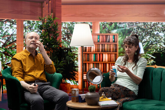 Elderly couple applying rejuvenating serum and doing daily routine together for skincare, to preserve their aging skin. Using moisturizer and UV protection cream on their cheeks. - Powered by Adobe