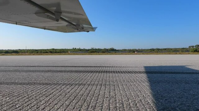 Lightweight airplane taking off from concrete runway. Side view from under the wing of the aircraft. Training flight at aviation school