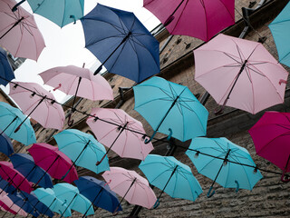 A lot of open umbrellas hanging in the air. Street decoration concept