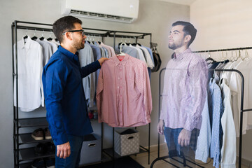 Obraz premium Man demonstrates augmented reality technology by virtually trying on a shirt