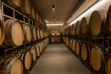 Wooden wine barrels in a winery, Warehouse of wine barrels.j