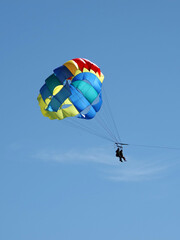 Two people parasailing high up in the sky