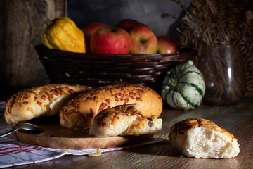 Apples, small pumpkins and fresh baked goods on a wooden table