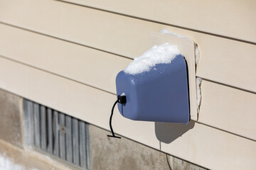 Outdoor faucet, water spigot, with snow on insulation cover. Home maintenance, winter weather...