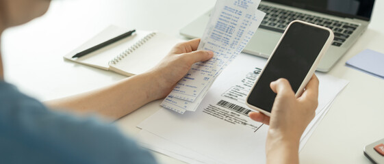 woman use phone scan barcode or QR codes to pay credit card bill after receiving document invoice....