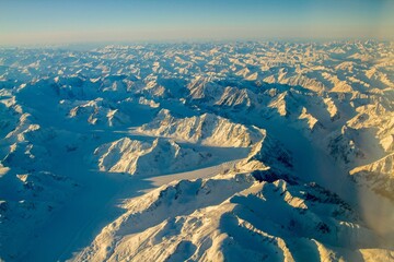 An aerial view of snow covered mountain ranges on a cold winter morning between Red Devil and Nome Alaska