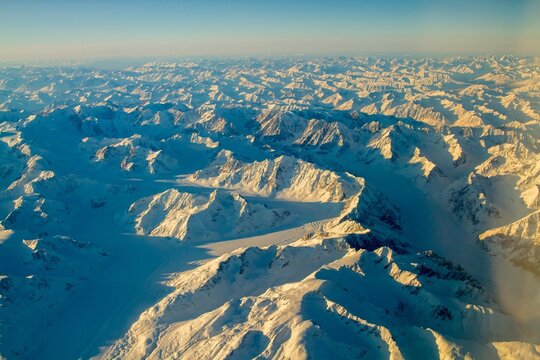 An aerial view of snow covered mountain ranges on a cold winter morning between Red Devil and Nome Alaska