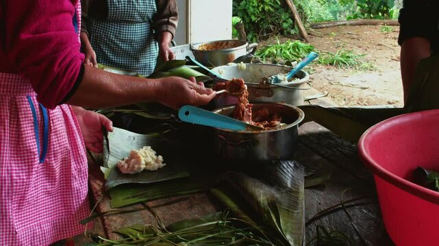 Adult women help prepare food for the family feast. The women make tamales.