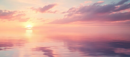 Fototapeta premium A calm, serene, and beautiful sunset over a still ocean. The sky is a soft pink and orange, with clouds reflecting in the water.