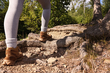 Young hiker in trekking shoes walking outdoors, closeup