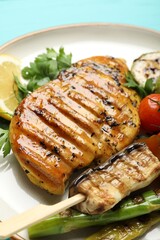 Delicious grilled vegetables and chicken breast on table, closeup