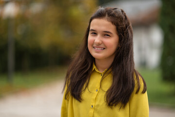 Portrait of a happy teenage girl outside.