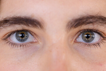 Close-up of woman's blue eyes gazing intently, capturing moment of reflection, at home