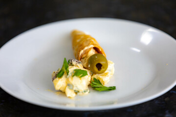 Traditional conical straws filled with mayonnaise, olives and parsley