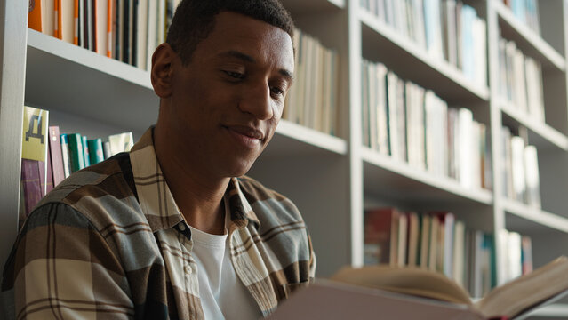 African American man guy library reading book textbook high school exam preparation university college academy study learning student reader bookworm male bookshelf literature hobby cognition science