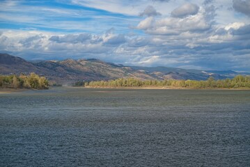 Serene River Landscape with Mountains and Clouds